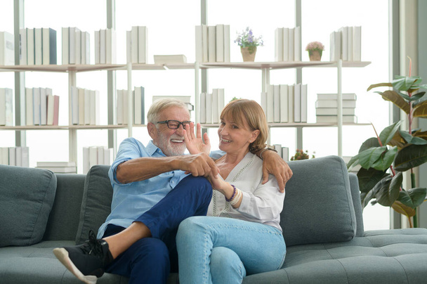 Happy Caucasian senior couple relaxing in living room  at home - Fotó, kép