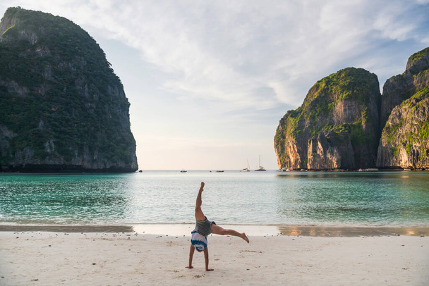 Asijské fit žena somersalt na bílém písku na pláži Maya kolem Phuket a Krabi, kroupy. Slavná destinace nebo letní rekreant v tropické zemi, Siam. Sport a zdravý životní styl. - Fotografie, Obrázek
