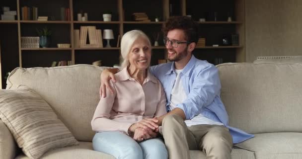 Older woman her adult son enjoy talk sit on sofa - Video