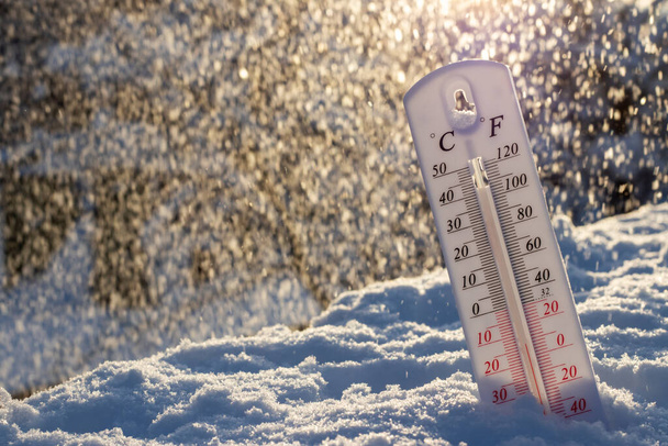 El termómetro en la nieve muestra bajas temperaturas en celsius o farenheit. En la puesta del sol. - Foto, Imagen