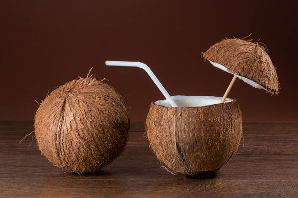 Coquetel de coco com uma palha no fundo marrom - Foto, Imagem