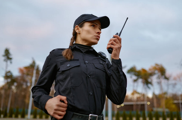 Servizio di pattuglia donna della polizia che parla in walkie-talkie - Foto, immagini