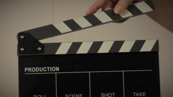 Movie slate or clapperboard hitting. Close up hand holding empty film slate and clapping it. Open and close film slate for video production. film production. color background studio. ready to shoot - Séquence, vidéo