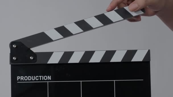 Movie slate or clapperboard hitting. Close up hand holding empty film slate and clapping it. Open and close film slate for video production. film production. color background studio. ready to shoot - Metraje, vídeo