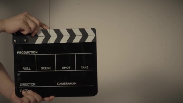 Movie slate or clapperboard hitting. Close up hand holding empty film slate and clapping it. Open and close film slate for video production. film production. color background studio. ready to shoot - Video, Çekim