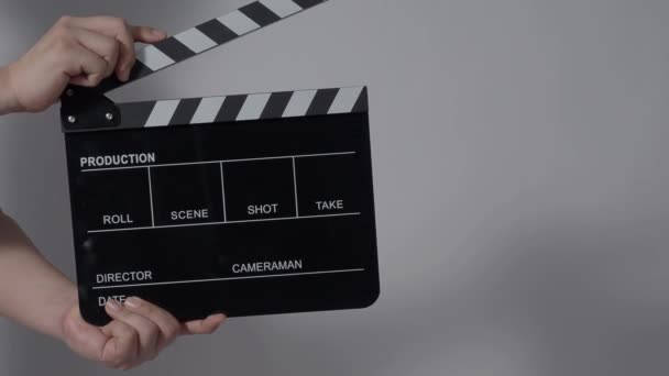 Movie slate or clapperboard hitting. Close up hand holding empty film slate and clapping it. Open and close film slate for video production. film production. color background studio. ready to shoot - Filmagem, Vídeo