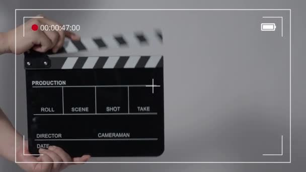 Movie slate or clapperboard hitting. Close up hand holding empty film slate and clapping it. Open and close film slate for video production. film production. color background studio. ready to shoot - Video