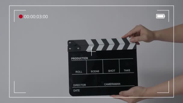 Movie slate or clapperboard hitting. Close up hand holding empty film slate and clapping it. Open and close film slate for video production. film production. color background studio. ready to shoot - Πλάνα, βίντεο
