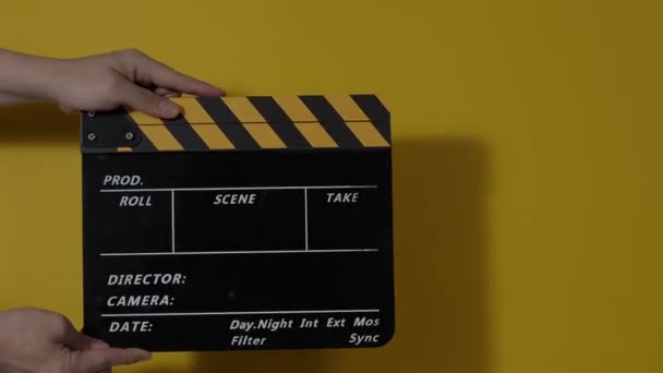 Movie slate or clapperboard hitting. Close up hand holding empty film slate and clapping it. Open and close film slate for video production. film production. color background studio. ready to shoot - Filmati, video