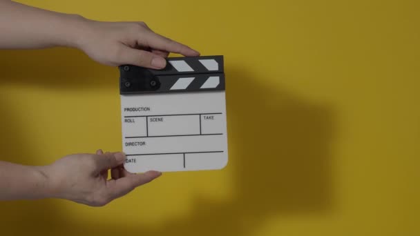 Movie slate or clapperboard hitting. Close up hand holding empty film slate and clapping it. Open and close film slate for video production. film production. color background studio. ready to shoot - Video, Çekim