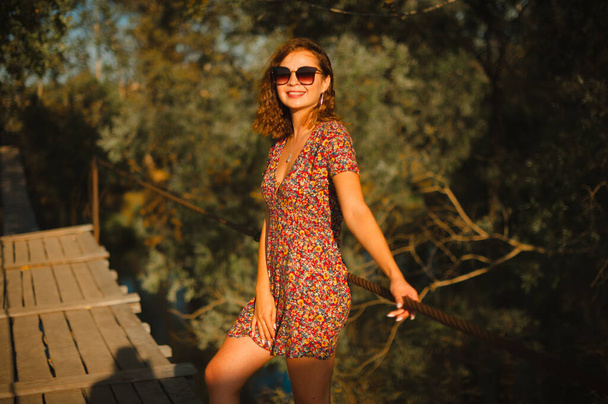 Felice ragazza caucasica sorridente alla telecamera. Ragazza passeggiate nella natura durante il tramonto. - Foto, immagini