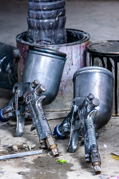 dvě kovové průmyslové barvy stříkací pistole s plechovkou vzadu pro lakování garáž pozadí - Fotografie, Obrázek