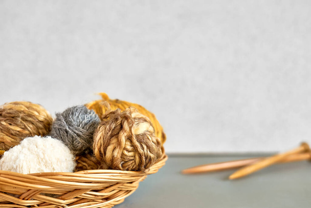 テーブルの上に毛糸と木製の編み針のボール。テキストのためのスペースとホビークラフトの背景。編み物、針仕事の概念. - 写真・画像