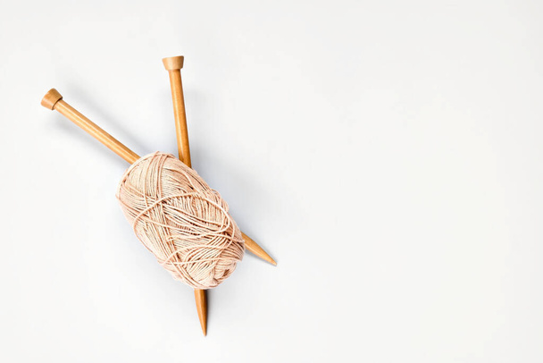 Ball of wool yarn and wooden knitting needles on the table top view. Hobby craft background with space for text. Concept of knitting, needlework. - Photo, Image