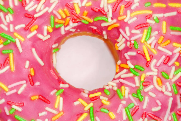 Pink donut close-up with colorful sprinkles close-up. Top View - Foto, Imagem