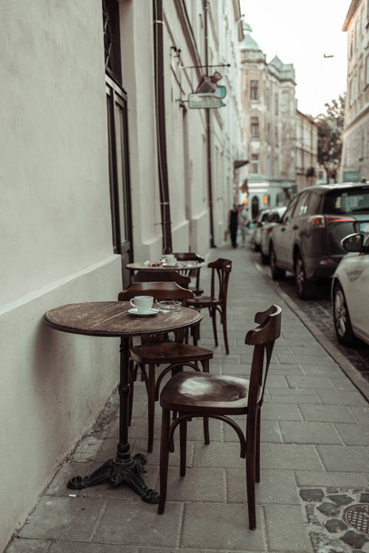 Street cafe στο κέντρο της lviv, Άδειο τραπέζια και καρέκλες στο κέντρο της παλιάς πόλης του Lviv σε μια ηλιόλουστη μέρα του καλοκαιριού - Φωτογραφία, εικόνα