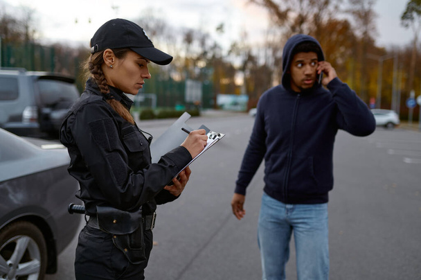 Расстроенный мужчина и женщина-полицейский выписывают штраф - Фото, изображение