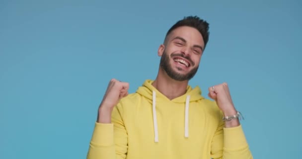 casual young man celebrating success, giving a like and waving his arm - Záběry, video