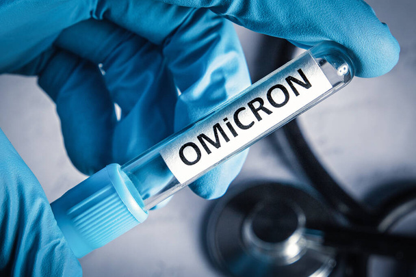 Doctor holding medical tube with sample of new variant of coronavirus mutations omicron. New covid 19 strain omicron, close-up. - Foto, Bild