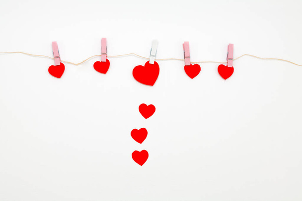 Red hearts with clothespins hanging on clothesline isolated on white background. Valentines Day - Photo, Image
