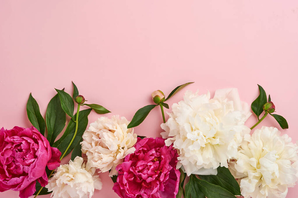 Beautiful red, pink and white peony flowers bouquet over pink background, top view, copy space, flat-lay. Valentines, Wedding and Mothers day background. - Fotó, kép