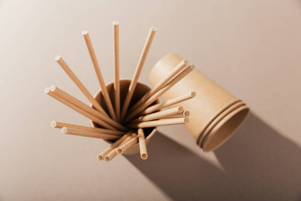 Disposable paper tableware. Cups and straws on beige background. Plastic free and zero waste concept. - Φωτογραφία, εικόνα