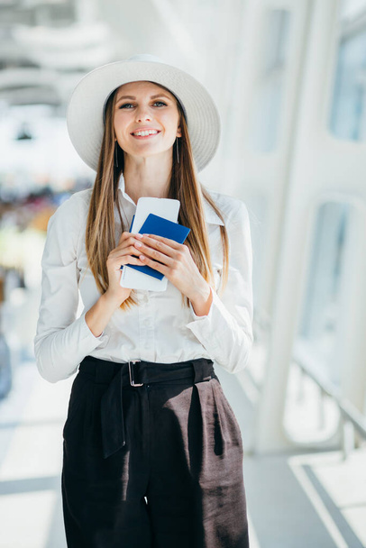 Vacaciones de verano. Mujer joven feliz en el sombrero de mimbre caminando en el aeropuerto con el equipaje, alegre señora milenial de Oriente Medio que va a la puerta de embarque de vuelo, listo para el viaje de vacaciones, Copiar el espacio - Foto, Imagen