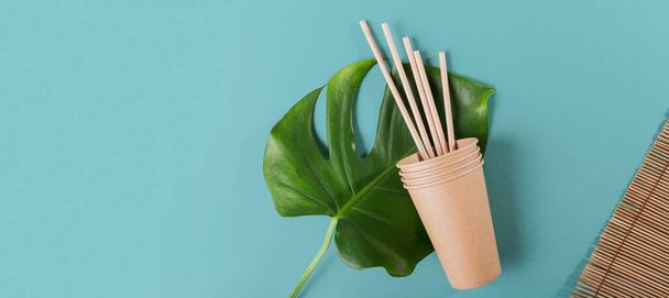 Disposable paper tableware. Craft paper cups and straws on light blue background. Plastic free and zero waste concept. - Photo, image