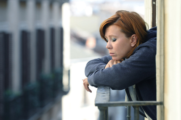 aantrekkelijke vrouw lijden aan depressie en stress alleen in pijn roken op het balkon  - Foto, afbeelding
