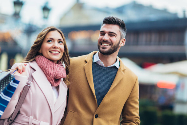 Porträt eines glücklichen Paares mit Einkaufstüten nach dem Einkauf in der Stadt. - Foto, Bild