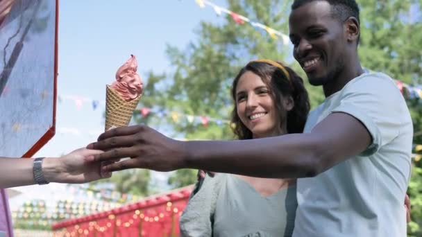 negro hombre compra helado conos y da porción a morena - Imágenes, Vídeo