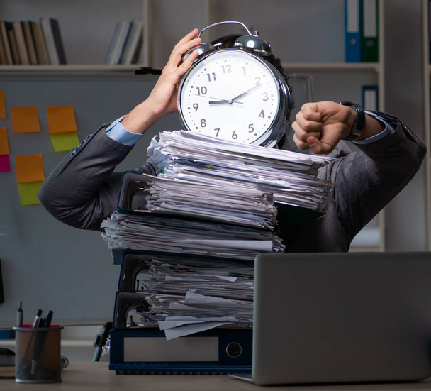 El joven empleado que trabaja hasta tarde en la oficina
 - Foto, Imagen
