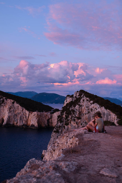 Lefkada,ギリシャ- 2021年9月9日:カップルキスで崖の夕日のコピースペースを楽しんで - 写真・画像