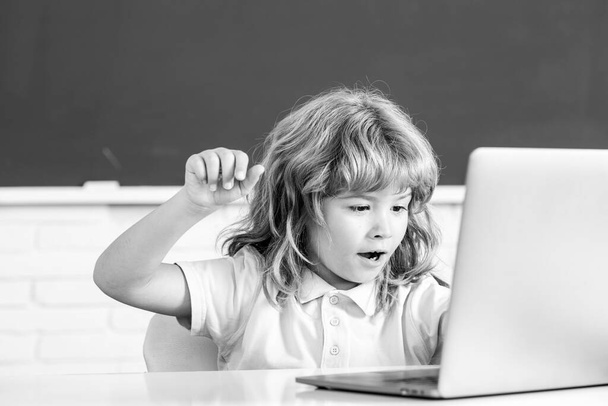 Шкільна дитина використовує цифровий ноутбук на уроках. Портрет смішного учня програмування початкової школи. Технологія онлайн-навчання, вебінар віртуальної освіти
. - Фото, зображення