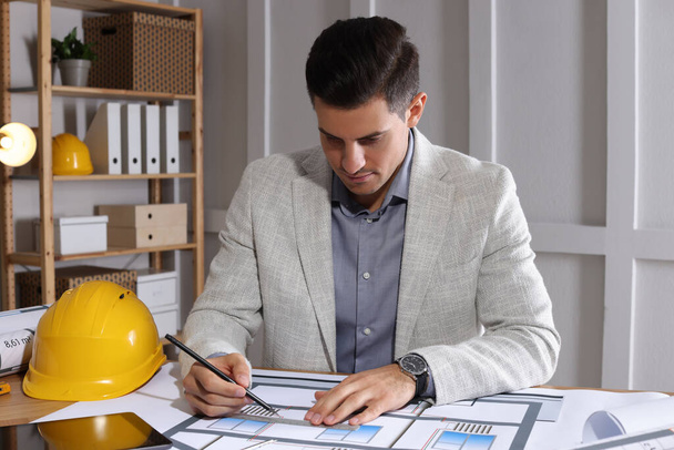 Architect working with construction drawings in office - Foto, Imagem
