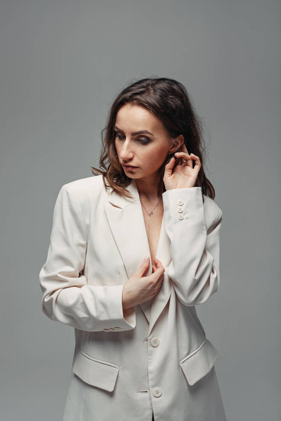 Stylish young woman dressed in a white jacket without underwear - Zdjęcie, obraz