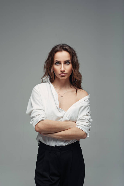 Confident pretty woman posing in black pants with a high waist and a white shirt. Business woman concept. - Fotoğraf, Görsel