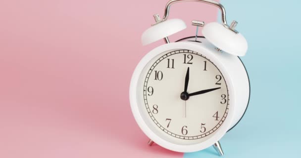 時間経過白い目覚まし時計は、時間を伝える1:10午後時間の実行と手の回転が表示されます。二つのトーンの背景に. - 映像、動画