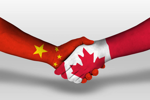 Poignée de main entre les drapeaux du Canada et de la Chine peints sur les mains, illustration avec chemin de coupe. - Photo, image