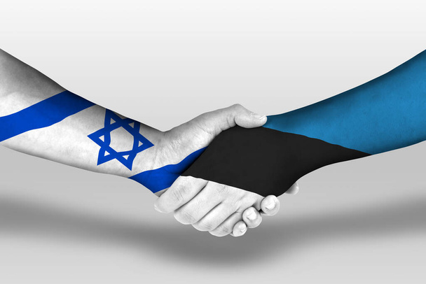 Poignée de main entre estonia et drapeaux israéliens peints sur les mains, illustration avec chemin de coupe. - Photo, image