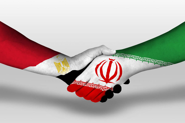 Handshake between iran and egypt flags painted on hands, illustration with clipping path. - Фото, зображення