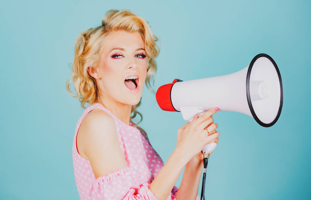 Young beautiful woman screaming in megaphone, isolated on background studio portrait. Shout girl speaks in a loudspeaker megaphone. - Photo, Image