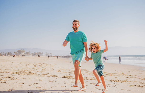 Dad and child having fun outdoors. Father and son running on sea. Childhood and parenting concept. - Foto, imagen