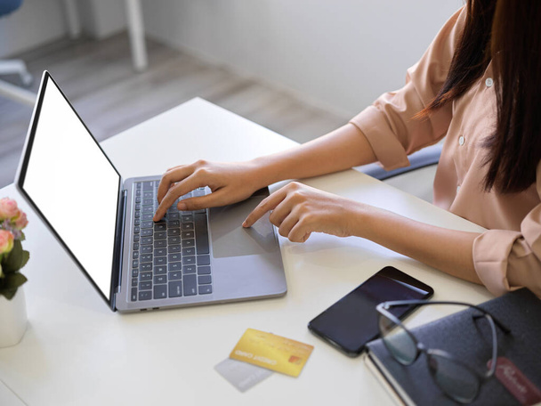 Imagen de cerca de una mujer de negocios asiática escribiendo en el teclado del ordenador portátil, la investigación de algunas informaciones en Internet. - Foto, imagen
