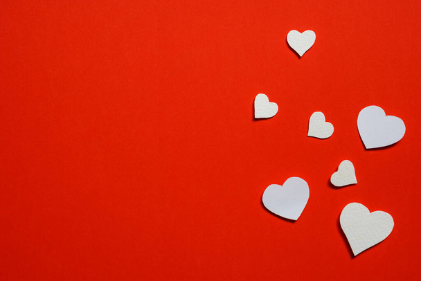 white paper cut into small hearts.  Paste on red paper, background concept for Valentine's .flat lay, copy space. - 写真・画像