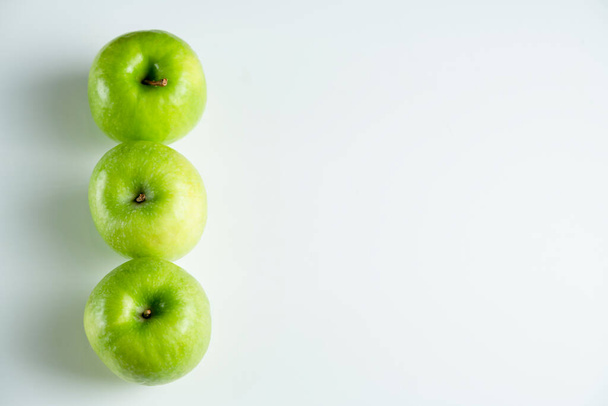 ένα ολόκληρο πράσινο μήλο σε λευκό φόντο - Φωτογραφία, εικόνα