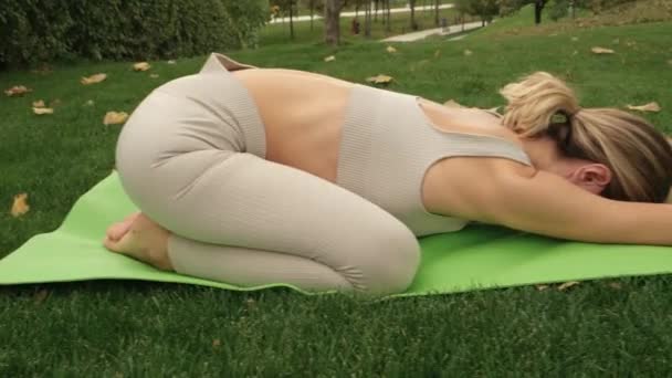 Egy nő jógázik a parkban. - Felvétel, videó