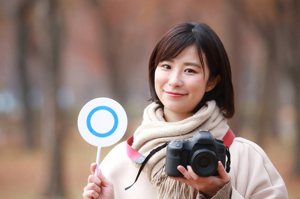 ázsiai nő holding camera and tag - Fotó, kép