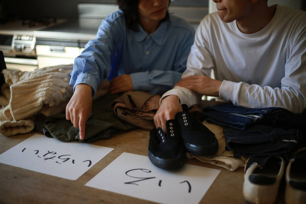 Как семейная пара сортирует одежду и обувь дома - Фото, изображение