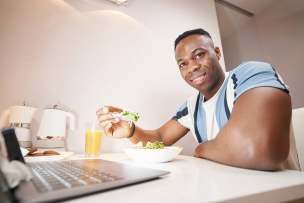 Man smiling while eating lunch at home - Foto, Bild